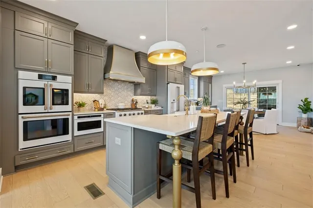 a kitchen with stainless steel appliances a stove a table and chairs in it