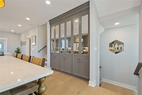 a view of kitchen island with stainless steel appliances wooden floor dining table and chairs