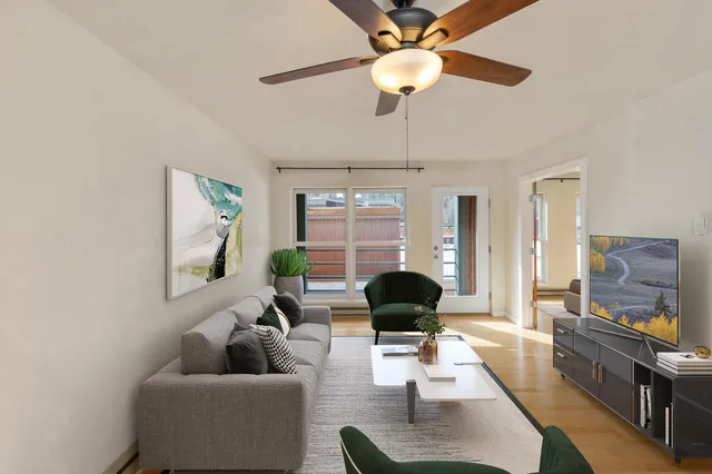 a living room with furniture a flat screen tv and a window
