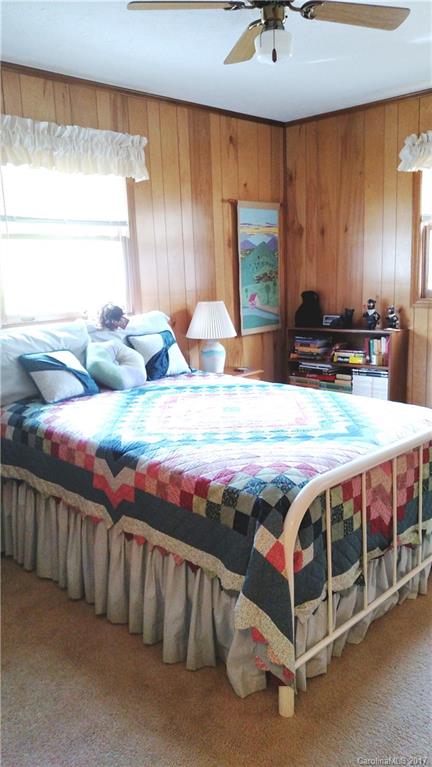 444 Stoney Ridge Loop, Unit 50 Maggie Valley, NC 28751 - Photo 11 of 19 a bedroom with a bed and a chandelier
