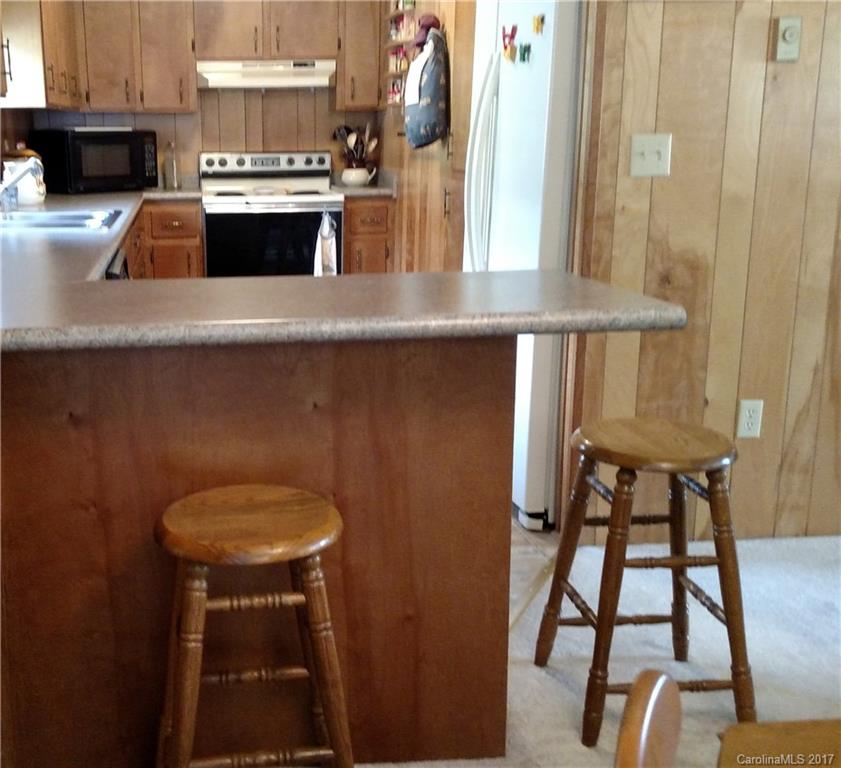 444 Stoney Ridge Loop, Unit 50 Maggie Valley, NC 28751 - Photo 4 of 19 a kitchen with kitchen island a stove and a sink