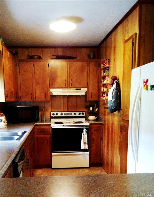 444 Stoney Ridge Loop, Unit 50 Maggie Valley, NC 28751 - Photo 5 of 19 a kitchen with stainless steel appliances granite countertop a stove a sink and a microwave