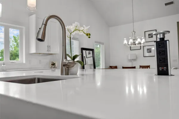 a view of a kitchen with a sink and chandelier