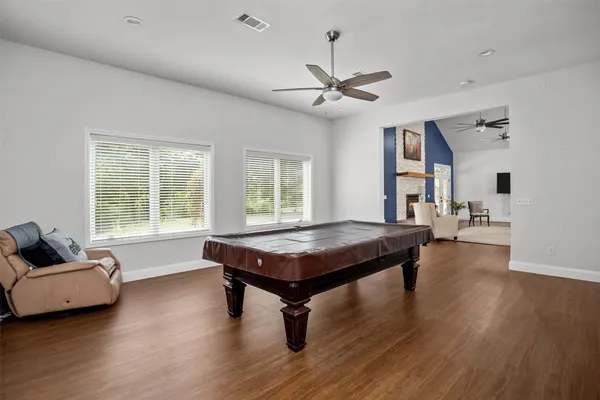 a living room with furniture a table and wooden floor