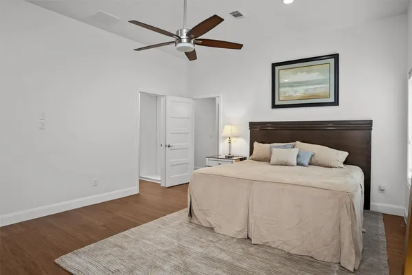 a bedroom with a large bed and a ceiling fan