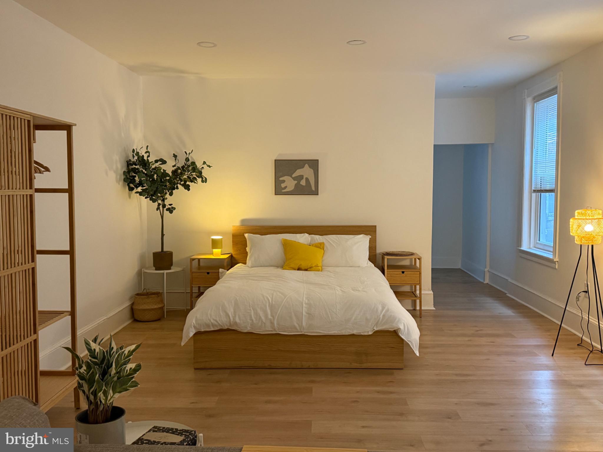 a bedroom with a bed and a potted plant