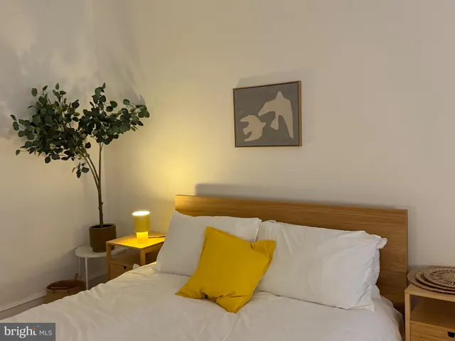 a bedroom with a bed and a plant