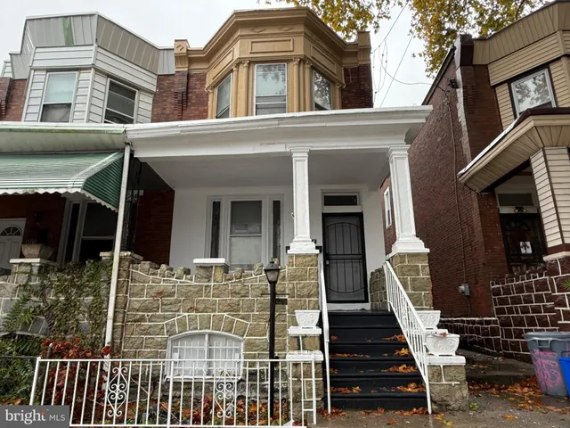 a view of a house with wooden deck and furniture