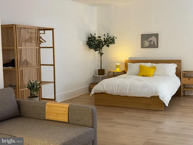 a bedroom with a bed and a potted plant