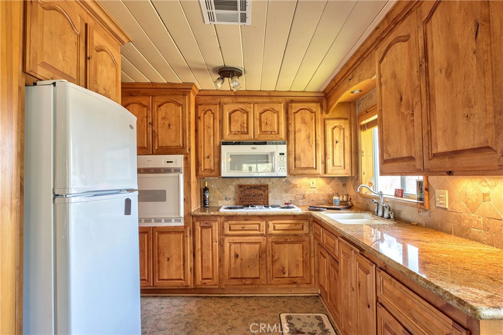 58111 Bonita Vista Road Mountain Center, CA 92561 - Photo 48 of 75 a kitchen with stainless steel appliances a refrigerator and a sink