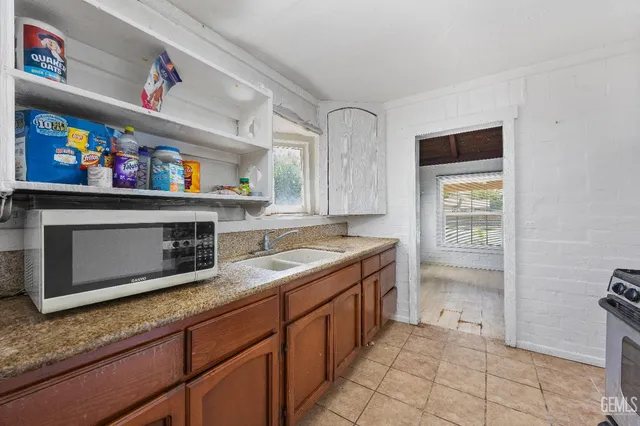 a kitchen with granite countertop a stove and a microwave
