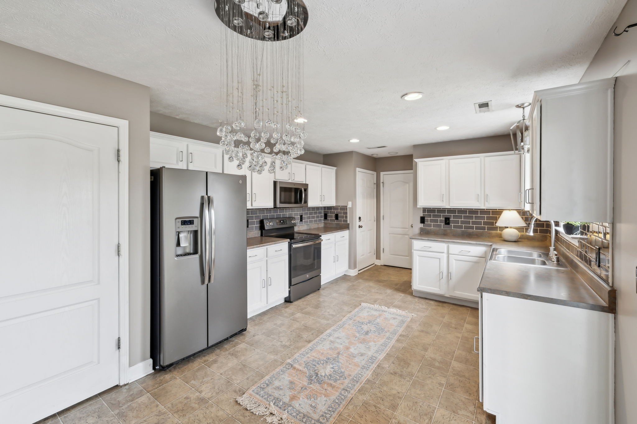325 Golfview Lane Springfield, TN 37172 - Photo 17 of 51 a kitchen with refrigerator a microwave and white cabinets
