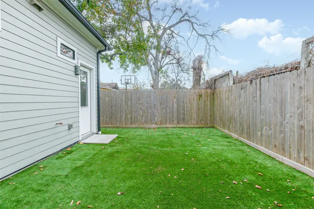 a view of a backyard with potted plants and large tree
