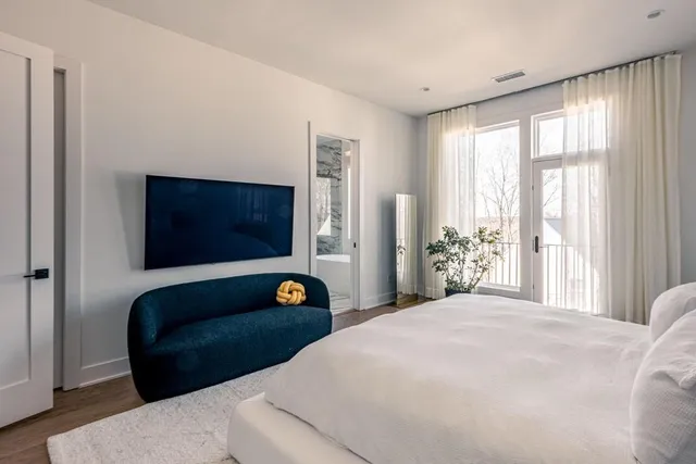 a bedroom with a bed a couch and a large window