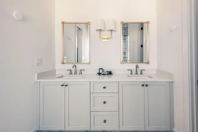 a bathroom with double sink and a mirror