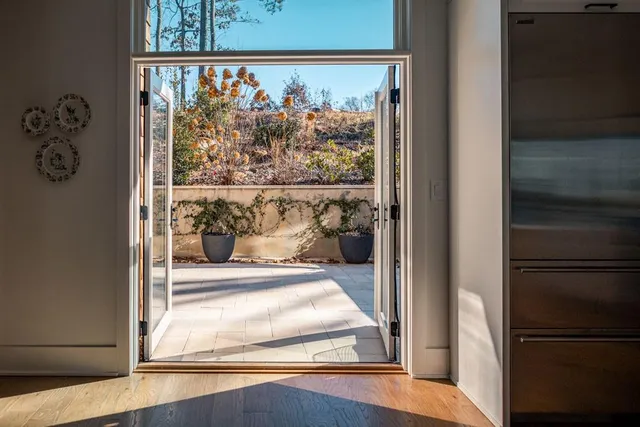 a view of a hallway with wooden floor and a living room
