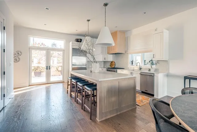 a kitchen with stainless steel appliances granite countertop a stove and a wooden floors