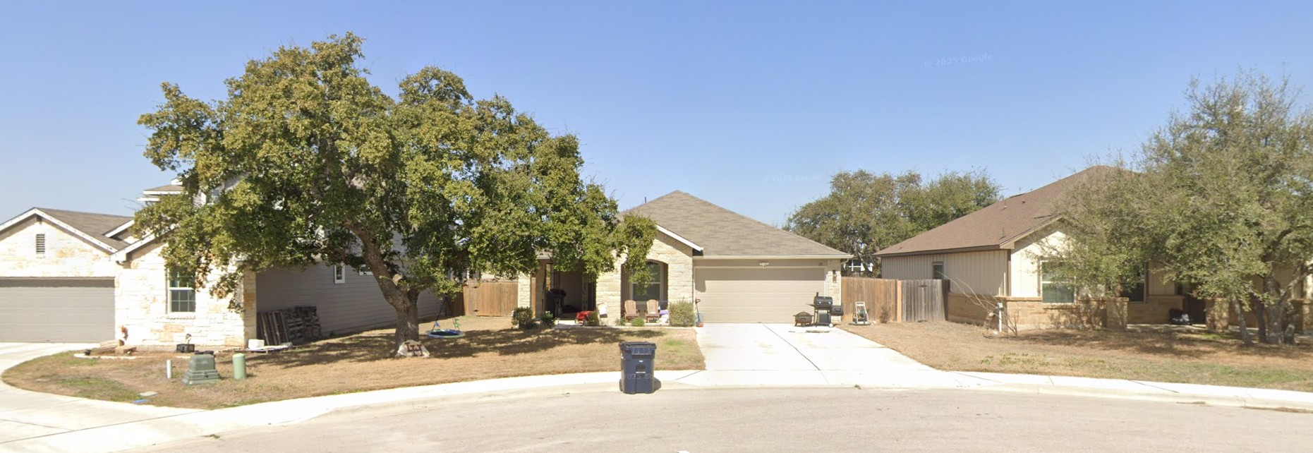 A well-maintained street view property with a spacious driveway and attached garage.