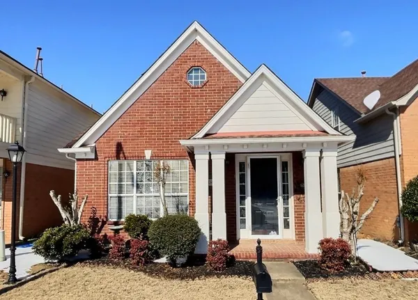 a view of a house with large windows and plants