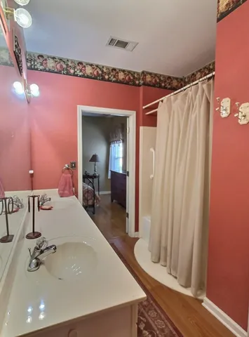 a bathroom with a sink a mirror and a shower