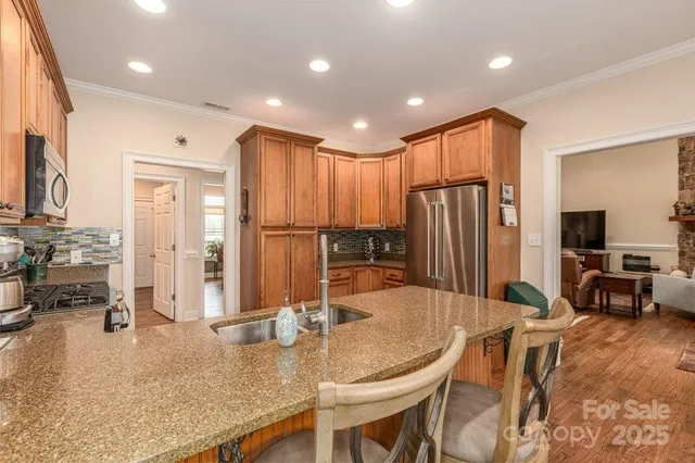 a kitchen with stainless steel appliances granite countertop sink refrigerator and cabinets