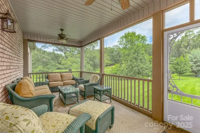 a living room with furniture and floor to ceiling windows