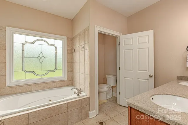 a bathroom with a granite countertop sink toilet and bathtub