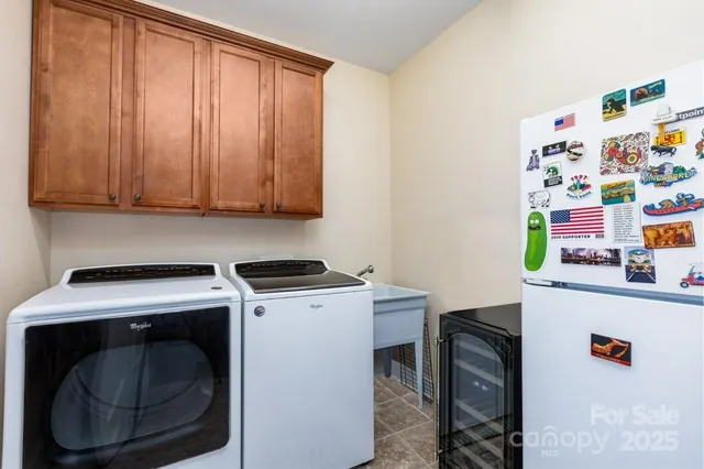 a utility room with fridge dryer and washer