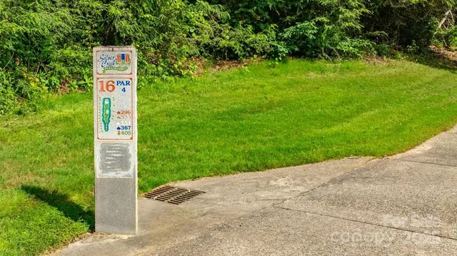 a sign that is sitting in the grass next to a road