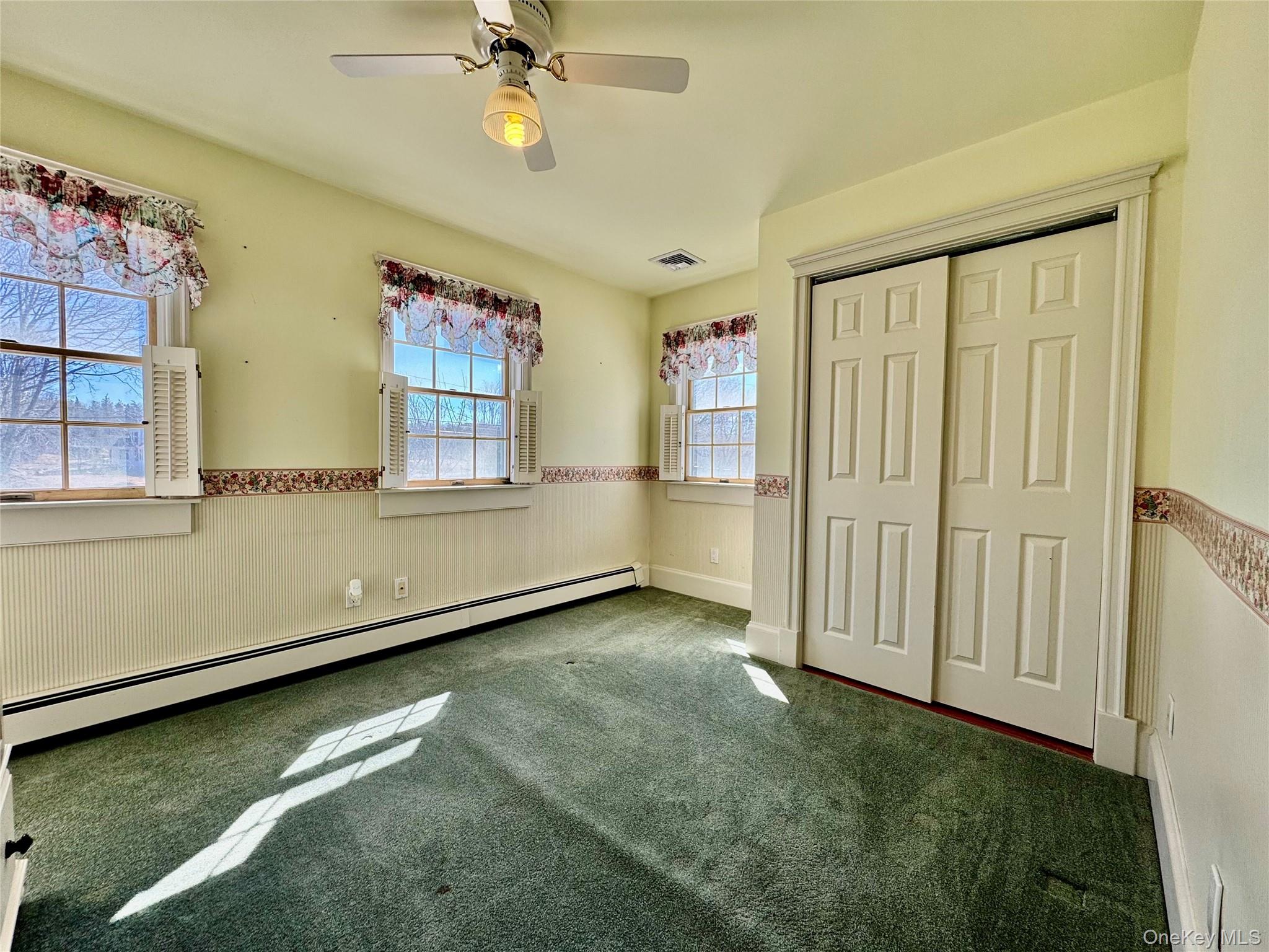 886 Sound Shore Road Riverhead, NY 11901 - Photo 29 of 39 3rd bedroom with large windows and a ceiling fan
