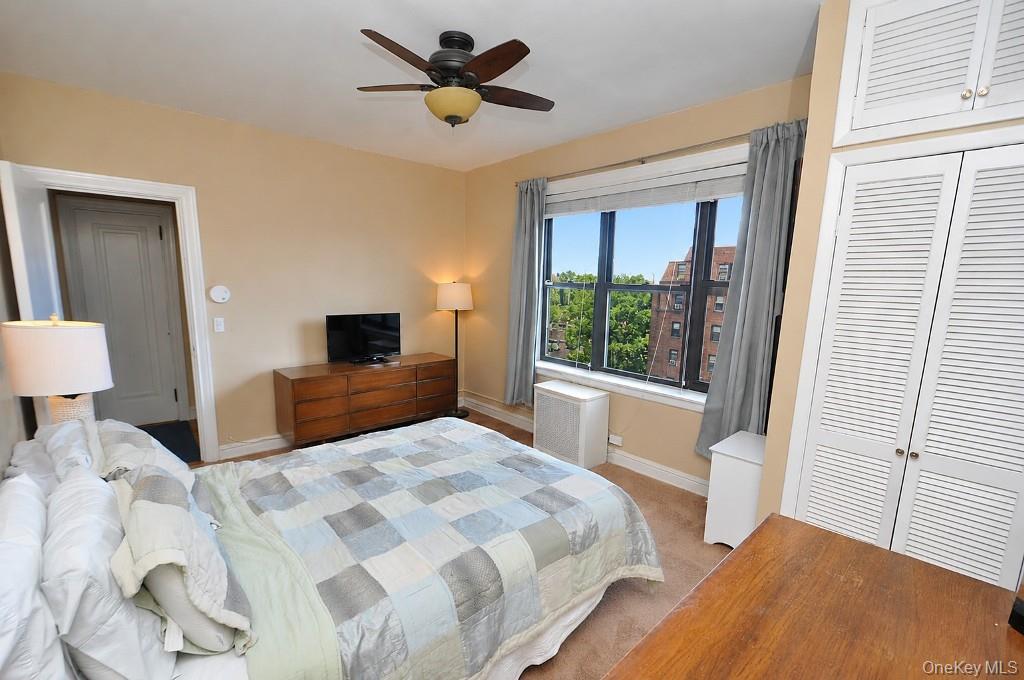 143 Garth Road, Unit 5J Scarsdale, NY 10583 - Photo 19 of 47 a bedroom with a large bed and a large window