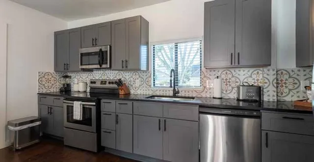 a kitchen with stainless steel appliances granite countertop a sink stove and microwave