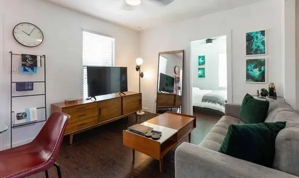 a living room with furniture a flat screen tv and a window