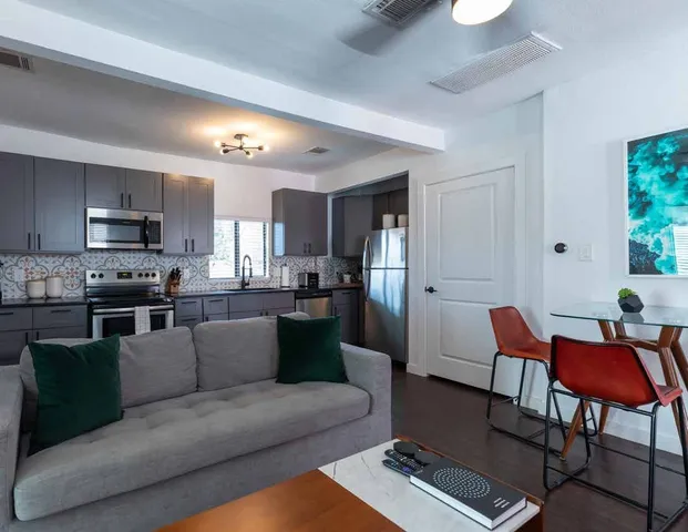 a living room with furniture and a dining table with kitchen view