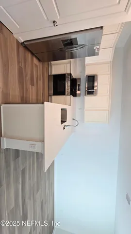 a kitchen with stainless steel appliances kitchen island sink refrigerator and microwave