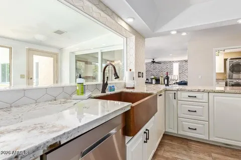 a kitchen with sink a stove and cabinets