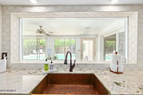 a kitchen with a granite countertop sink and window
