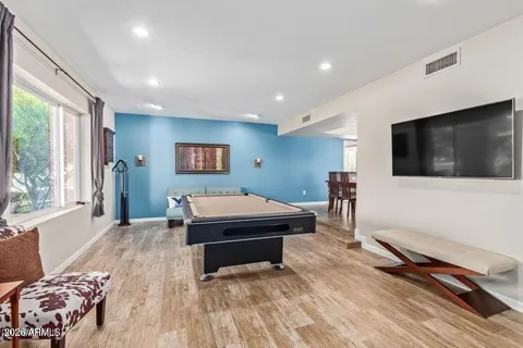 a living room with a flat screen tv on dresser and a table