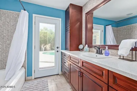 a spacious bathroom with a granite countertop sink and a mirror