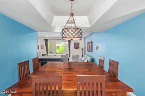 a dining room with furniture a chandelier and window