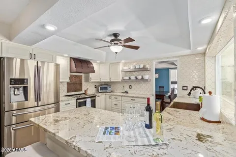 a kitchen with stainless steel appliances kitchen island granite countertop a refrigerator sink and stove
