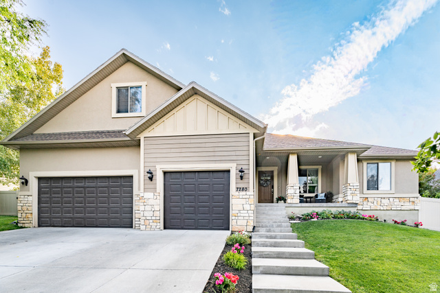 7280 Point Lookout Road Eagle Mountain, UT 84005 - Photo 1 of 26 View of front facade with stone siding, covered porch, and concrete driveway