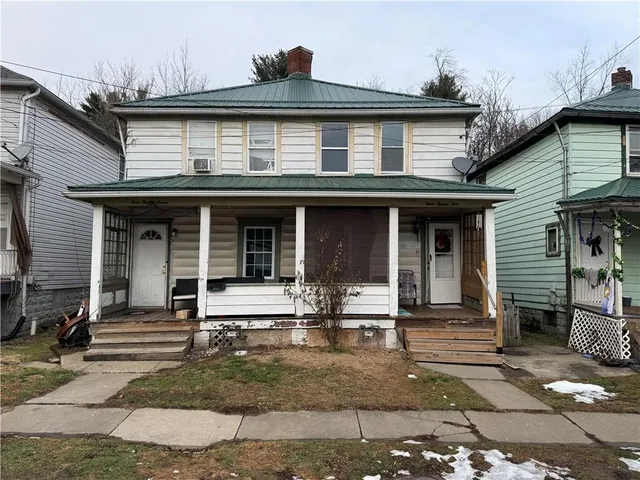 a front view of a house with chair and tables