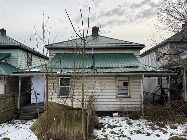 a view of a house with a wooden fence