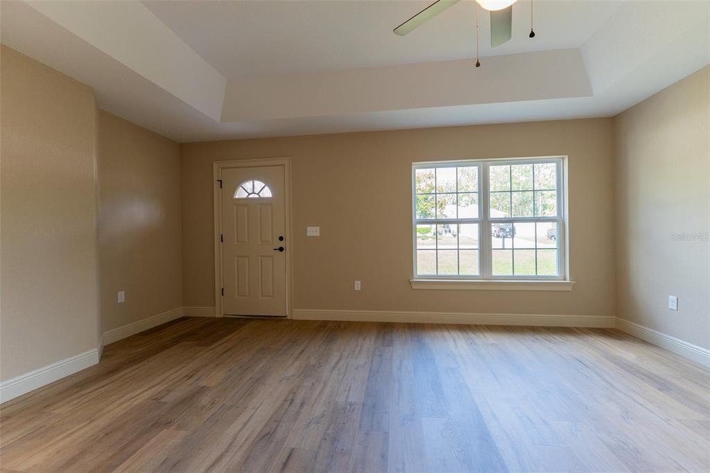 5497 Southwest 151 Street Road Ocala, FL 34473 - Photo 5 of 65 a view of an empty room with wooden floor and a window