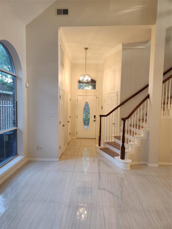 4175 Midrose Trail Dallas, TX 75287 - Photo 4 of 14 Foyer featuring light-toned tile flooring, a staircase with wood-finish handrails, and a decorative front entry door with an oval glass insert