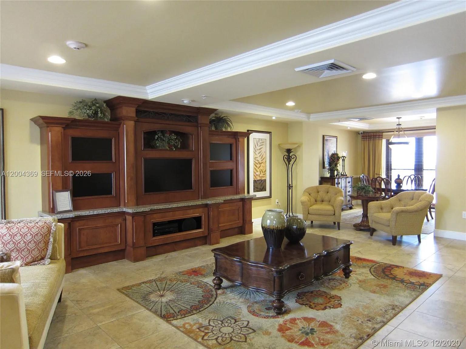 888 Douglas Road, Unit 1512 Coral Gables, FL 33134 - Photo 3 of 12 a living room with furniture and a flat screen tv