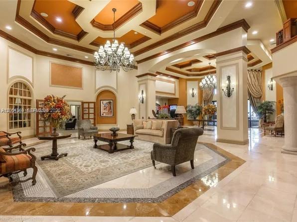 888 Douglas Road, Unit 1512 Coral Gables, FL 33134 - Photo 6 of 12 a living room with fireplace furniture and a chandelier