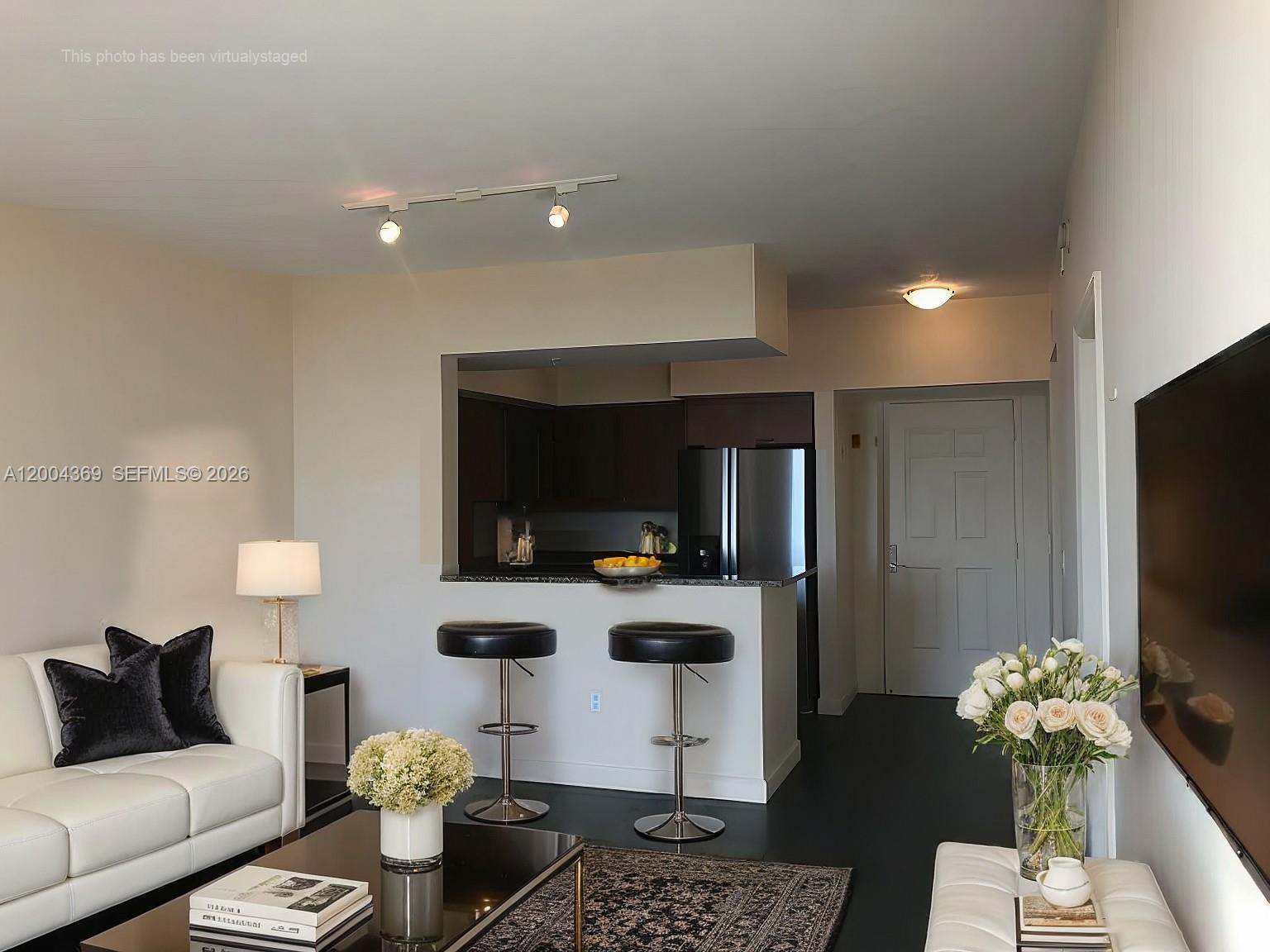 888 Douglas Road, Unit 1512 Coral Gables, FL 33134 - Photo 8 of 12 a living room with furniture and a flat screen tv