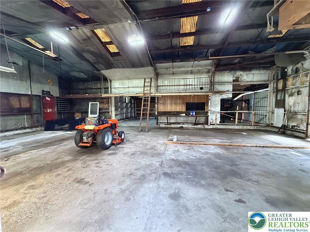 4995 Mountain Road Slatington, PA 18080 - Photo 27 of 30 A spacious, open-concept workshop with high ceilings offers versatile space for various projects.